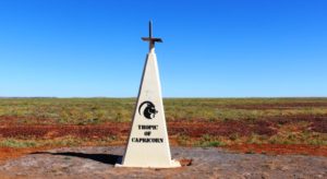 The marker for the Tropic of Capricorn sits by the road where it crosses a treeless plain