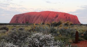 The setting sun touches the top of Ayers Rock